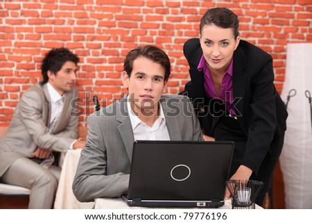 Young co-workers watching laptop