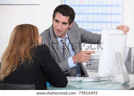 Man showing woman computer screen