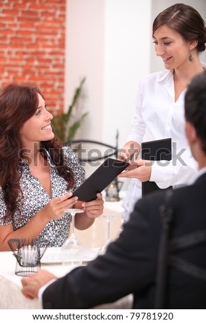 portrait of a waitress with couple at restaurant