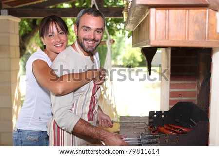 Smiling couple preparing barbecue