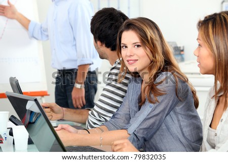 women and a man behind computers and listening at a meeting or vocational training