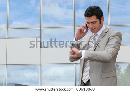 Businessman outside looking at watch
