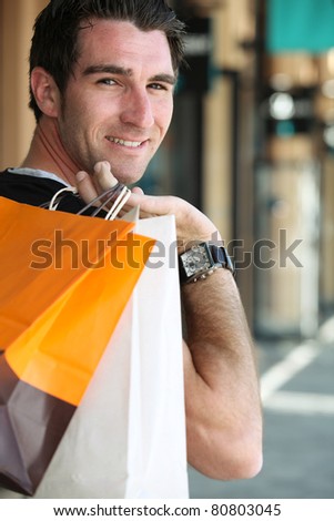 Man carrying shopping bags over shoulder