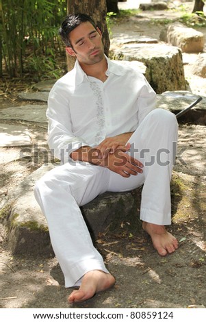 30 years old man sleeping and leaning against a tree