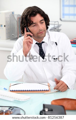 Doctor using a telephone at a desk