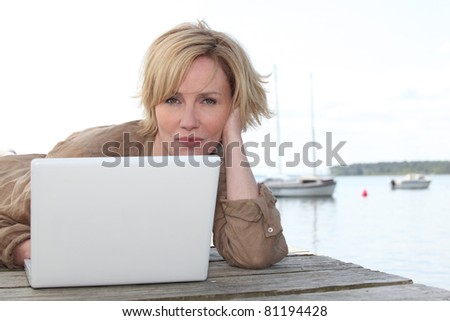Woman on laptop by the lake