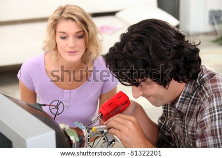 Couple repairing television