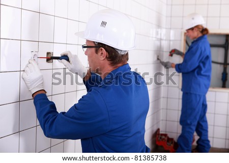 Two electricians working in public rest room