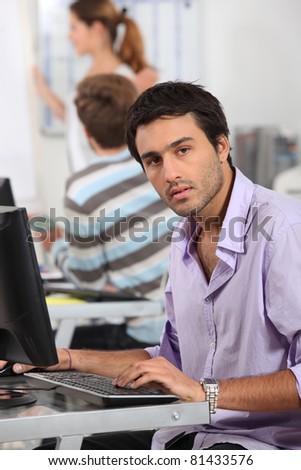 Young man typing at a computer keyboard