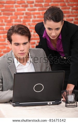 Man and woman in restaurant with laptop computer
