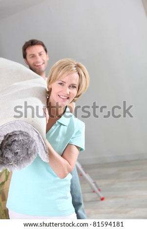 Couple carrying carpet roll