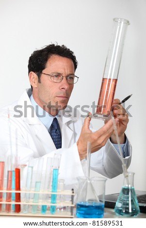 Laboratory technician examining liquid in a graduated cylinder