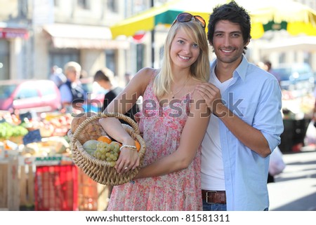 Couple at a market with basket of produce