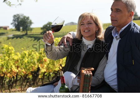 Couple tasting wine in vineyard