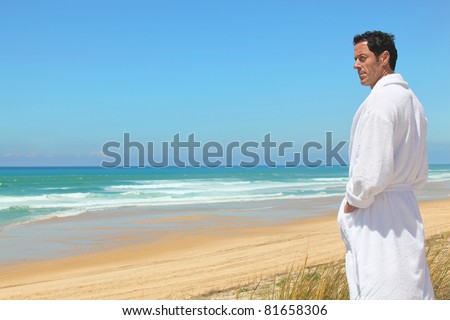 Man on the beach in towel robe