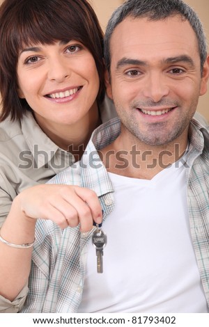 Mid life couple with the keys to their new home