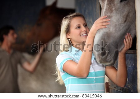 man and woman cuddling a horse