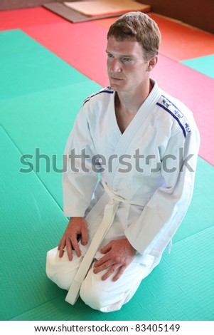 Kneeling man on judo mat
