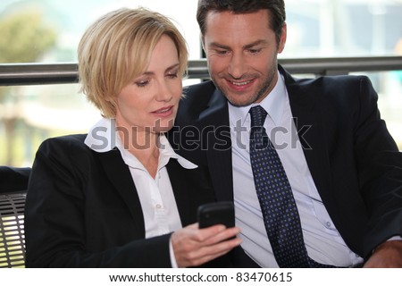 Businessman and woman looking at phone