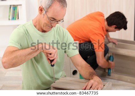Father and son putting together flat pack furniture