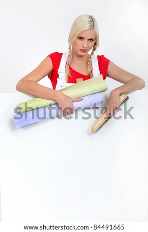 Young woman with rolls of wallpaper