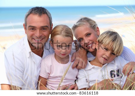 two parents and their two children in front of the sea
