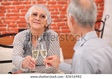 older couple toasting at restaurant