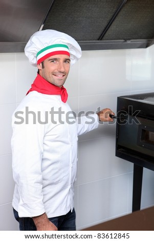 Italian chef next to a pizza oven