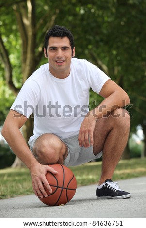 Man crouching with basket ball