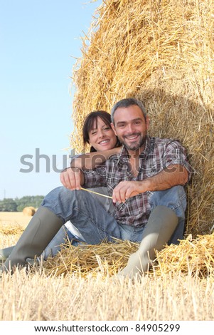 Farmer and wife sat on hay bale
