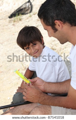 A father teaching his son how to fish.