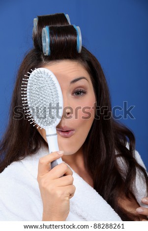 Funny woman with hair rollers and brush