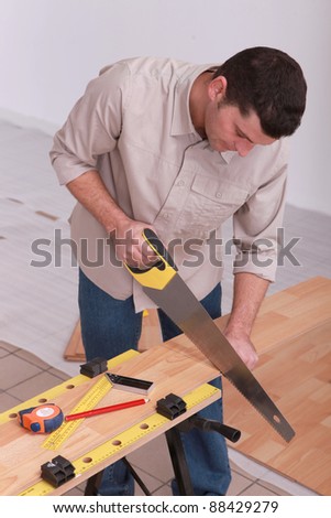 Man sawing laminate flooring