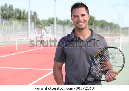 tennis player posing in front of a tennis court
