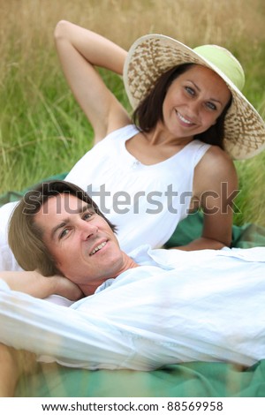 40 years old man and woman relaxing and  lying down in a meadow