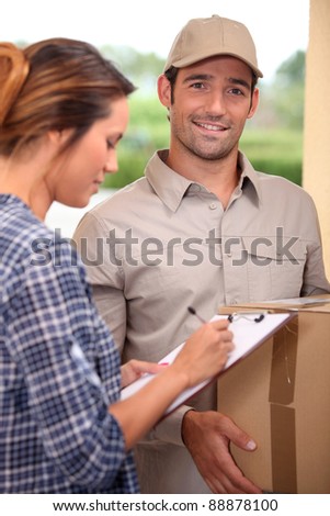Woman signing for a courier delivered parcel