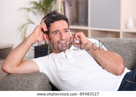 Man with telephone relaxing on sofa