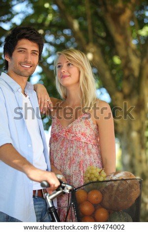 Couple with a bike and basket of produce