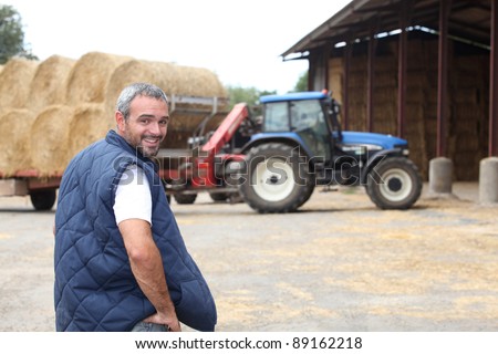 Famer stood by hay barn
