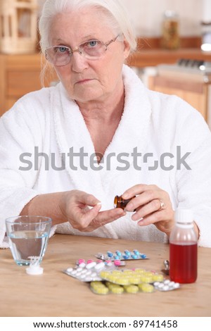 Unhappy elderly lady taking her medication