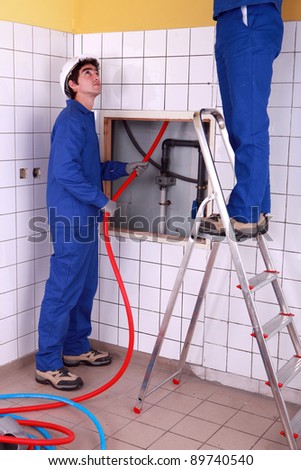 Two plumber fixing bathroom water supply