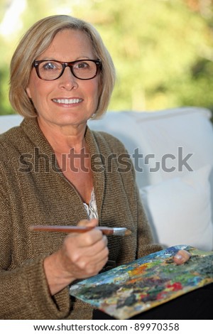 A middle age woman painting.