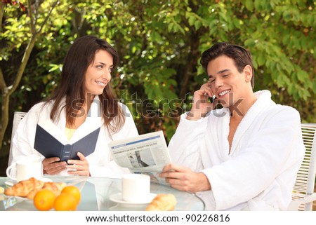 Couple reading over an outdoor breakfast