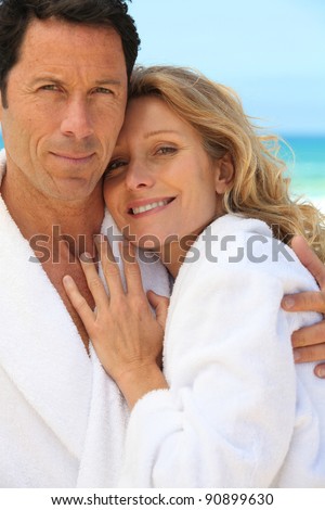 Couple in toweling robes by the ocean