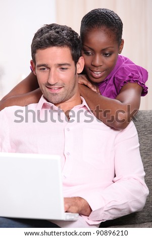 Couple looking at a laptop computer at home