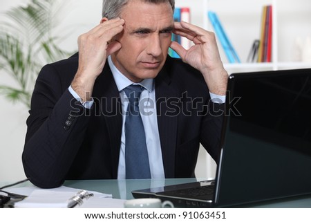 Stressed businessman sat at desk