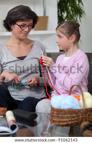 little girl and grandmother knitting together