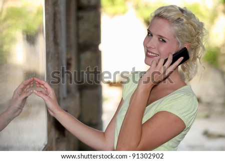 Blond woman outside restaurant on mobile telephone