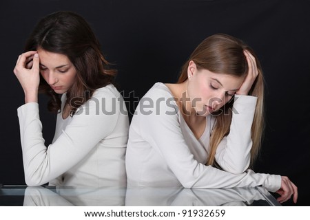 sisters sitting back to back after quarrel