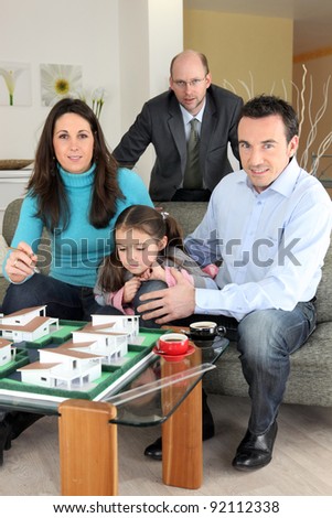 Architect with a family looking at a construction model